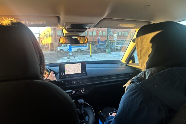 A pair of volunteer observers patrol south Minneapolis neighborhoods Tuesday, Jan 27, 2026, looking for signs of activity by federal immigration officers. (AP Photo/Tim Sullivan)