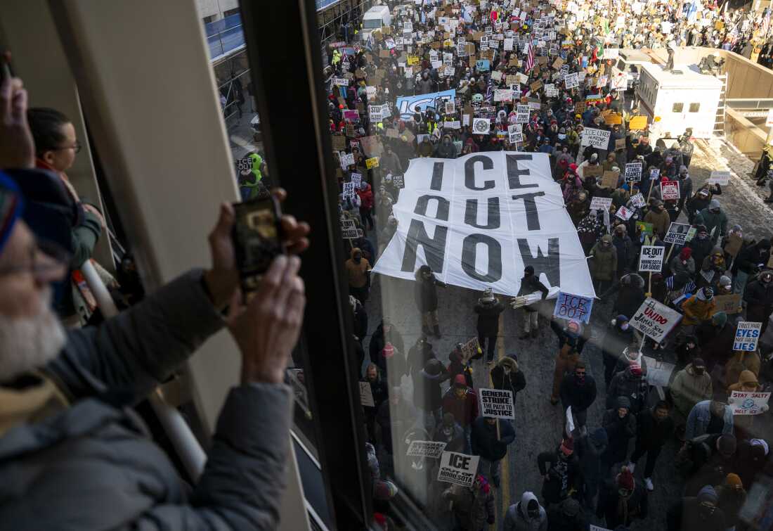 People look on from a skyway as demonstrators march during a "Nationwide Shutdown" demonstration against ICE enforcement on Friday in Minneapolis.