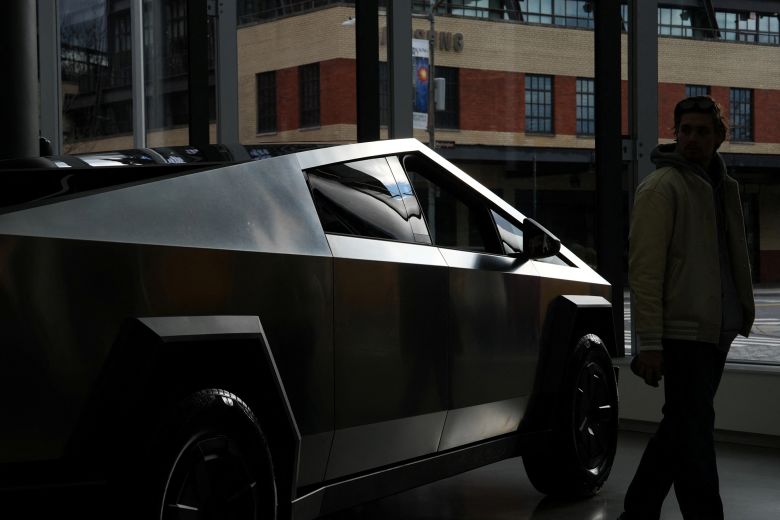 A person looks at a Tesla Cybertruck at a Tesla showroom in New York.