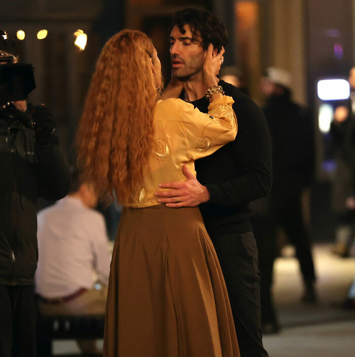 Blake Lively in a tense moment with a man on a city street while a camera crew films nearby, fans reacting strongly.