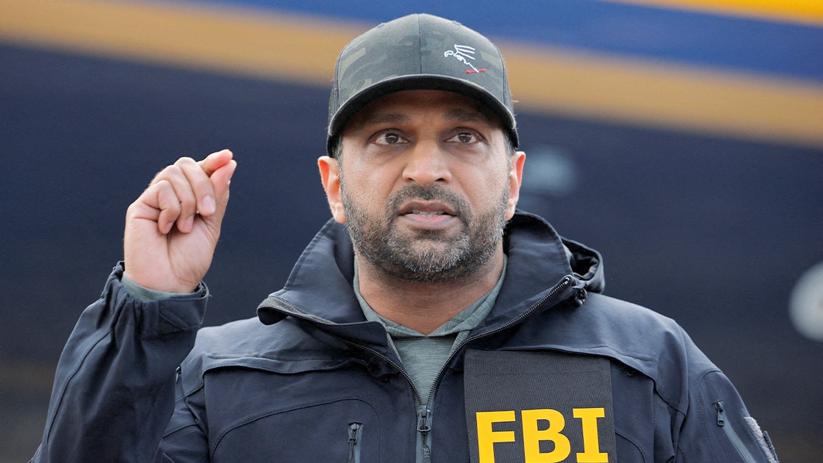 A federal official speaks at a podium with FBI insignia during a press conference announcing a major fugitive arrest.