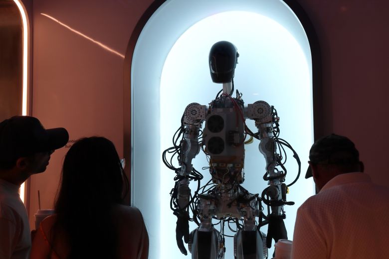 Customers view a humanoid robot at the Tesla Diner and Drive-In restaurant in Los Angeles.