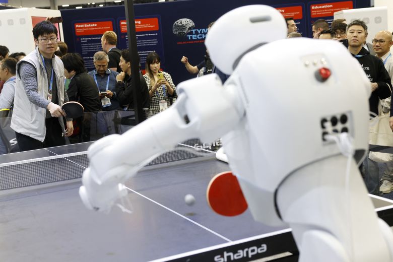 An attendee plays table tennis with a Sharpa robot during the annual Consumer Electronics Show in Las Vegas, on January 7.