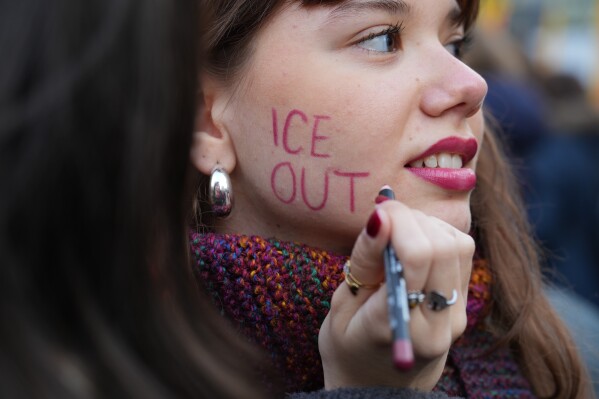 A person takes part in an Anti-ICE demonstration, ahead of the 2026 Winter Olympics, in Milan, Italy, Saturday, Jan. 31, 2026. (AP Photo/Antonio Calanni)