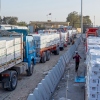 Trucks carrying humanitarian aids line up to enter the Egyptian gate of the Rafah crossing, heading for inspection by Israeli authorities before entering the Gaza Strip, in Rafah, Egypt, Sunday, Feb. 1, 2026.