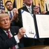 President Trump displays the GENIUS Act — the first major crypto legislation passed by Congress — after signing it in the White House in Washington, D.C., on July 18, 2025.