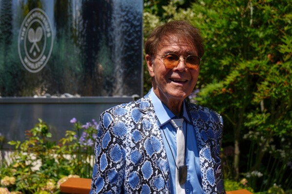 Singer Cliff Richard poses for a photo as he arrives for day eleven at the Wimbledon Tennis Championships in London, July 10, 2025. (AP Photo/Joanna Chan, File)