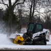 A plow clears snow from a snow-covered sidewalk during a cold day in Lake Forest, Ill., Wednesday, Jan. 21, 2026.