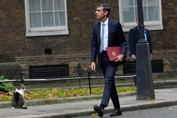 New British Prime Minister Rishi Sunak arrives as Larry the cat sits at Downing Street in London, Tuesday, Oct. 25, 2022, after returning from Buckingham Palace where he was formally appointed to the post by Britain's King Charles III. (AP Photo/Frank Augstein, File)