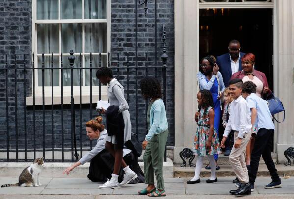School children approach Downing Street chief mouser Larry the cat, as they leave after a scheduled meeting with Britain's Prime Minister Boris Johnson at 10 Downing Street in London, Friday, Aug. 30, 2019. (AP Photo/Frank Augstein, File)