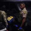 Law enforcement personnel from the Pima County Sheriff's Department and the FBI work on a Range Rover in a Culver’s restaurant parking lot in Tucson, Arizona, early Saturday.