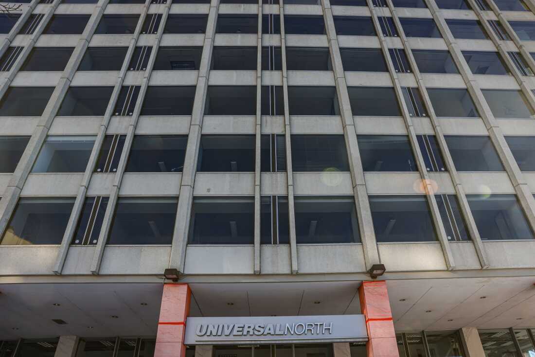 The exterior of an office-to-residential building conversion under construction. The building is concrete and has a sign that says "Universal North."