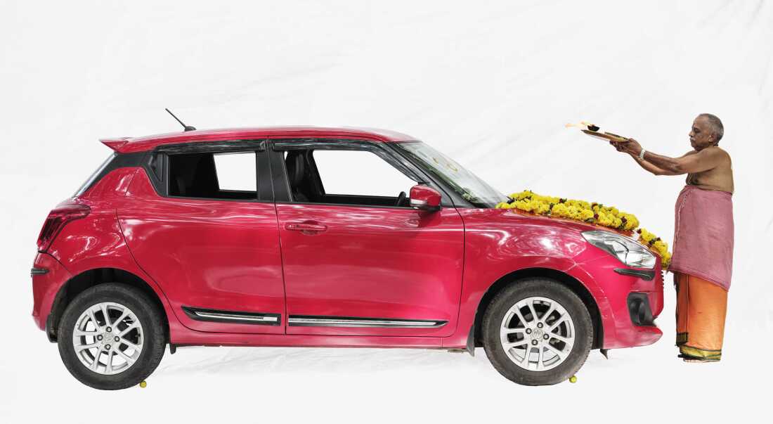 The priest Nagabushna chants prayers to protect a new car from misfortune and accidents, in Bengaluru, India.