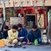 Truck drivers eat on the ground by their stalled vehicles near Torkham, Pakistan, on Oct. 13, 2025. More than three months later, the Torkham border remains closed with no end in sight.