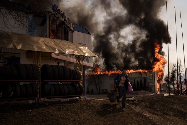 A man recovers items from a shop that caught fire in a Russian attack in Kharkiv, Ukraine, Friday, March 25, 2022. (AP Photo/Felipe Dana, File)