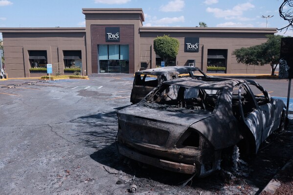 Charred vehicles sit in a parking lot sit outside a shopping mall in Guadalajara, Jalisco state, Mexico, Sunday, Feb. 22, 2026, as authorities reported that the Mexican Army killed Jalisco New Generation Cartel leader Nemesio Oseguera, known as "El Mencho." (AP Photo/Alejandra Leyva)