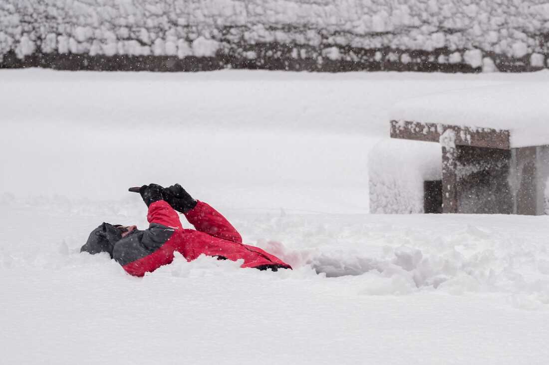 A man makes a recording while laying in the snow in lower Manhattan during a snow storm on Feb. 23 in New York.