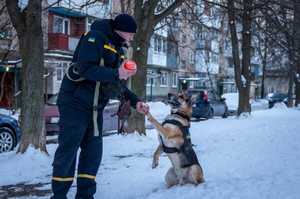 Ivan Khmelnytski, 25, a rescue worker, plays with his dog after work in Bila Tserkva, Ukraine, Saturday, Feb. 21, 2026. (AP Photo/Dan Bashakov)