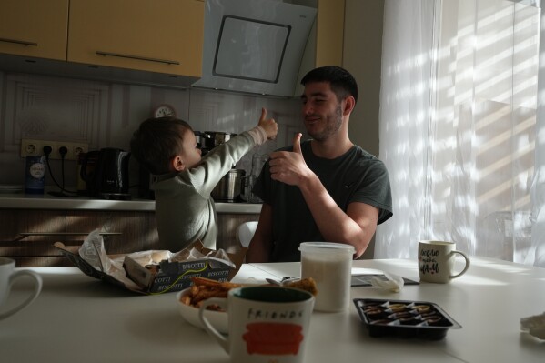 Davyd Osypenko, right, plays with his brother Hlib, 5, in Kyiv, Ukraine, Thursday, Feb. 19, 2026, nearly four years after their father was killed in a Russian airstrike. (AP Photo/Sergei Grits)