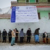 PUL-E ALAM, AFGHANISTAN -- JANUARY 17: Afghan men wearing masks to prevent the spread of Covid-19 line up as the UN World Food Program (WFP) distributes a critical monthly food ration, with food largely supplied by the US Agency for International Development (USAID), to 400 families south of Kabul in Pul-e Alam, Afghanistan, on January 17, 2022. This food delivery to Logar province comes as the UN warns that 23 million Afghans, more than half the population, are on the verge of famine, following a severe drought and as winter deepens, while the US and World Bank have only partially released funds frozen when the Taliban took control of Afghanistan in August 2021. The UN has made an emergency appeal for $5.5 billion to feed the hungry and forestall further economic collapse.