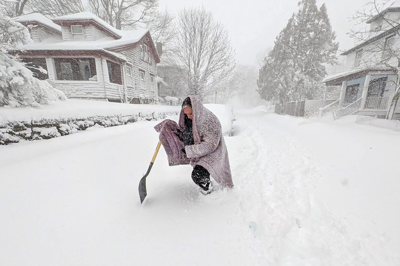 A woman wades through the deep snow as she tries to make her way to her car to retrieve her jacket as a blizzard makes its way across New Bedford, Massachusetts on Feb. 23.