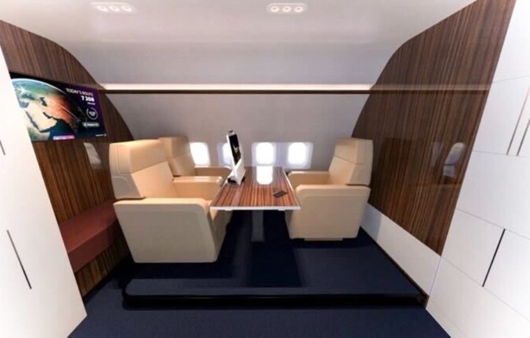 Three beige booth seats surround a table inside of a plane
