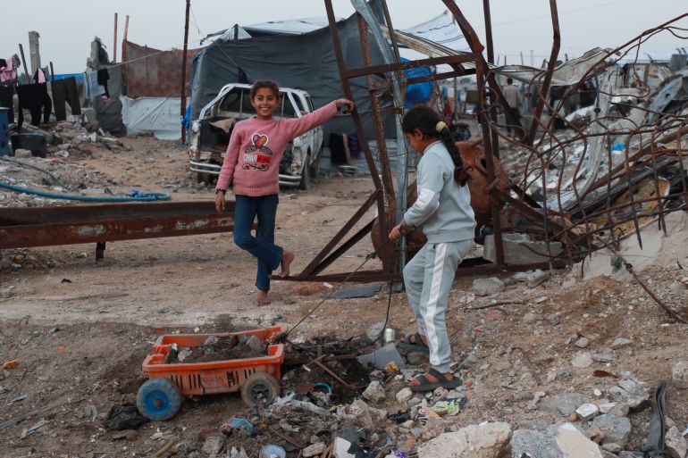 Children play beside the rubble and destroyed buildings in the Deir al-Balah area of central Gaza on February 20, 2026 [Abdelhakim Abu Riash/ Al Jazeera]