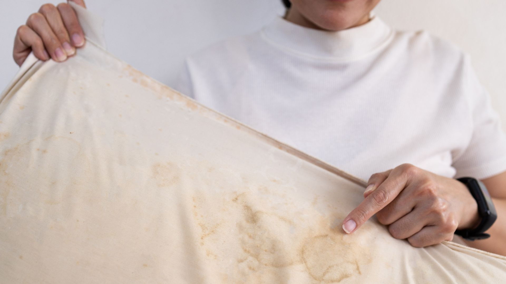 Woman pointing to a yellow stain on a mattress