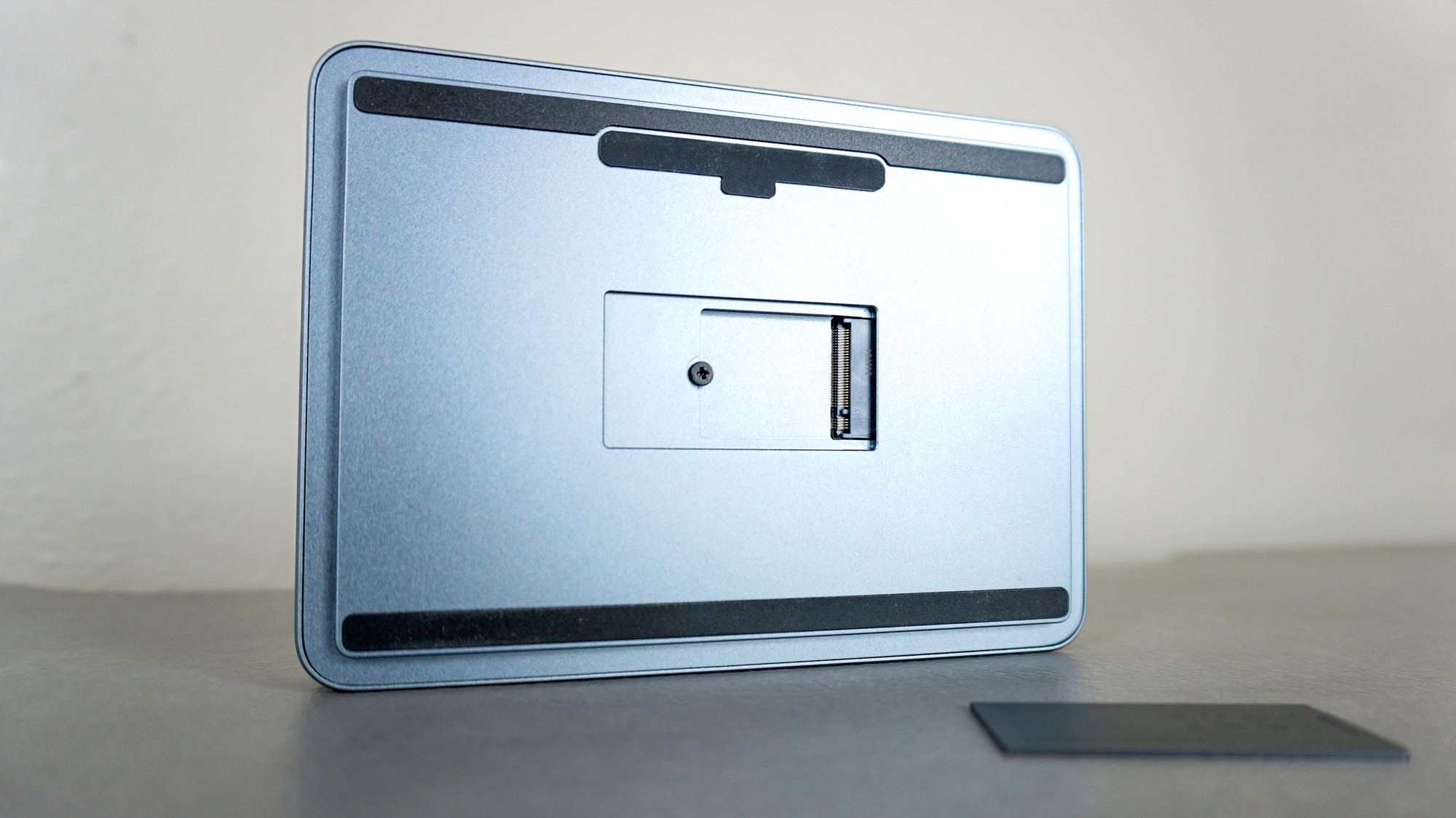 The Khadas Mind 2S seen from its underside with its magnetic SSD cover opened