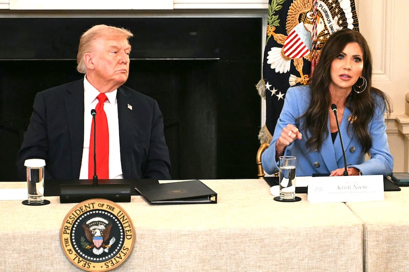 US President Donald Trump listens to HomelandSecurity Secretary Kristi Noem speak.