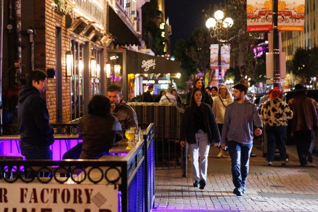 San Diego, California - February 20: People walk on the sidewalk at the Gaslamp Quarter in downtown San Diego on Friday, February 20, 2026. Previously, the street was closed to vehicular traffic. (Kristian Carreon / The San Diego Union-Tribune)