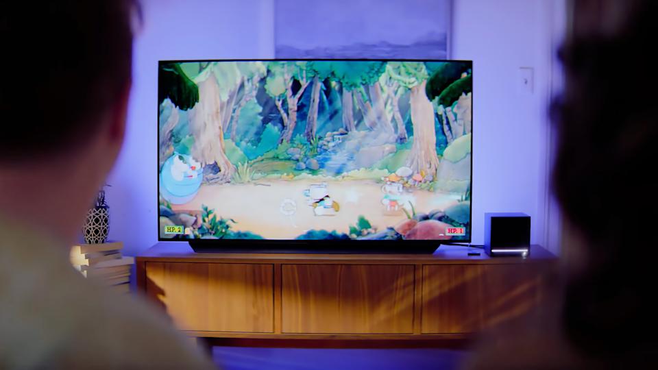 A Steam Machine connected to a TV playing the game Cuphead.