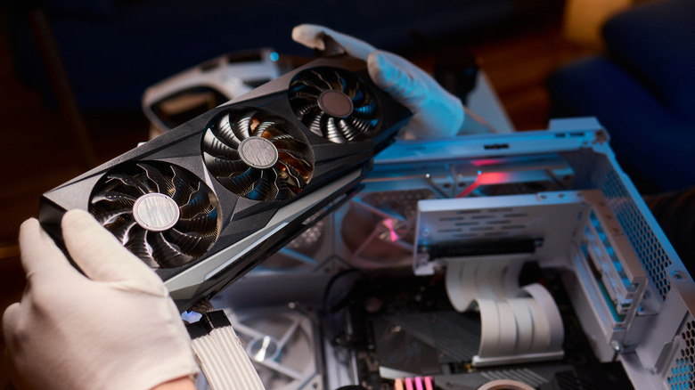 Person wearing gloves installing high-performance GPU into a gaming PC