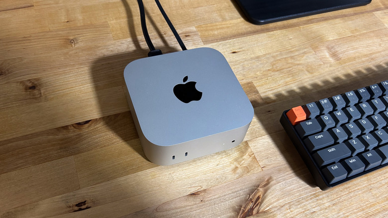 Apple Mac Mini on desk near keyboard.