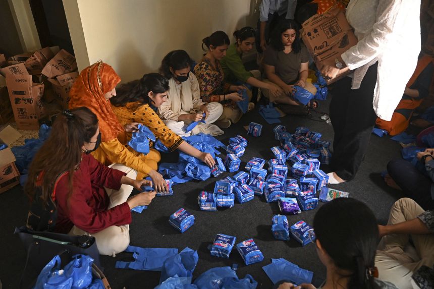 Volunteers pack sanitary pads for women displaced by flooding, in Lahore, on August 31, 2022. Seasonal flash floods worsened by the climate crisis have exacerbated period poverty.