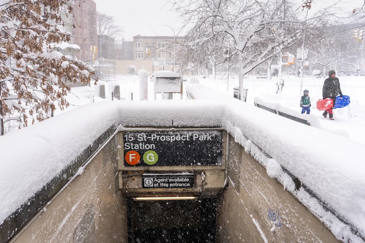 A family walks alongside Prospect Park with slides amid heavy snow on Feb. 23 in the Brooklyn borough of New York City. 