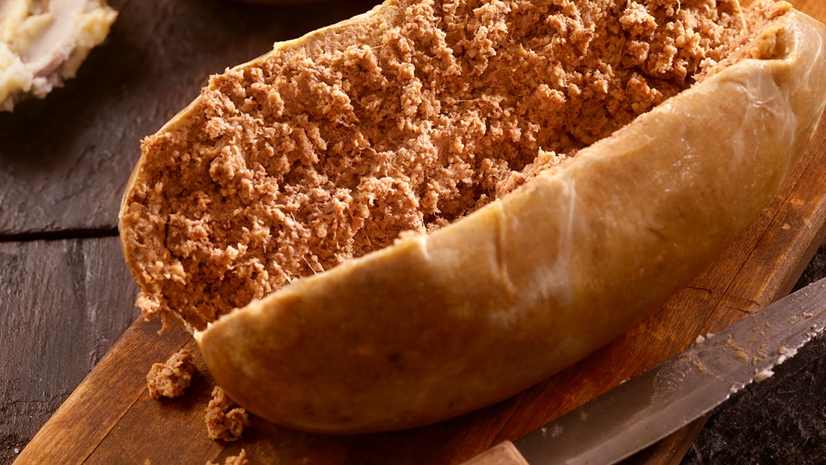 Haggis meat cut open on plate.