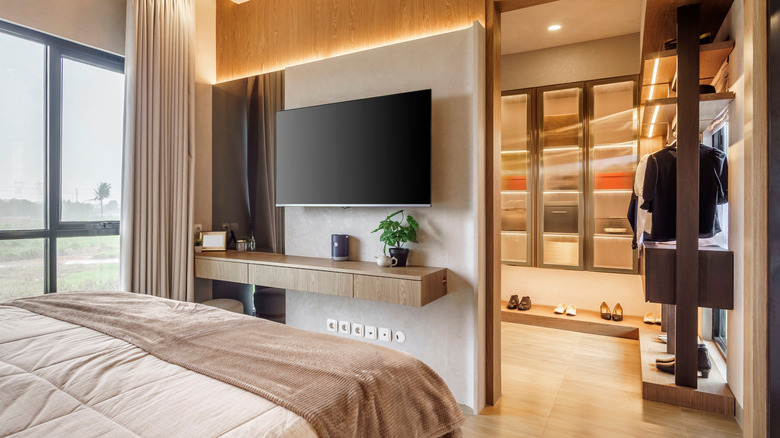 A TV set in a bright bedroom.