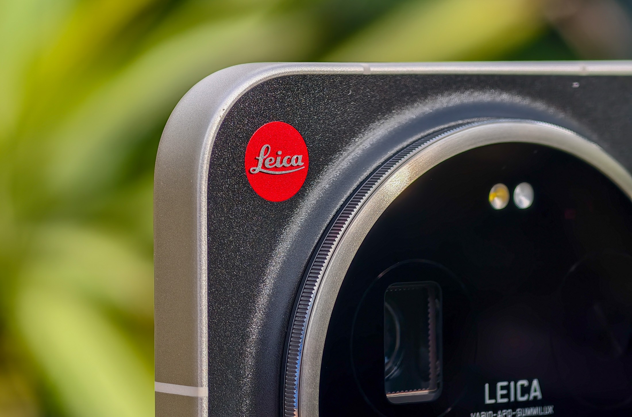 Photo of the Xiaomi Leica Leitzphone on a table outside, focusing on the Leica logo.