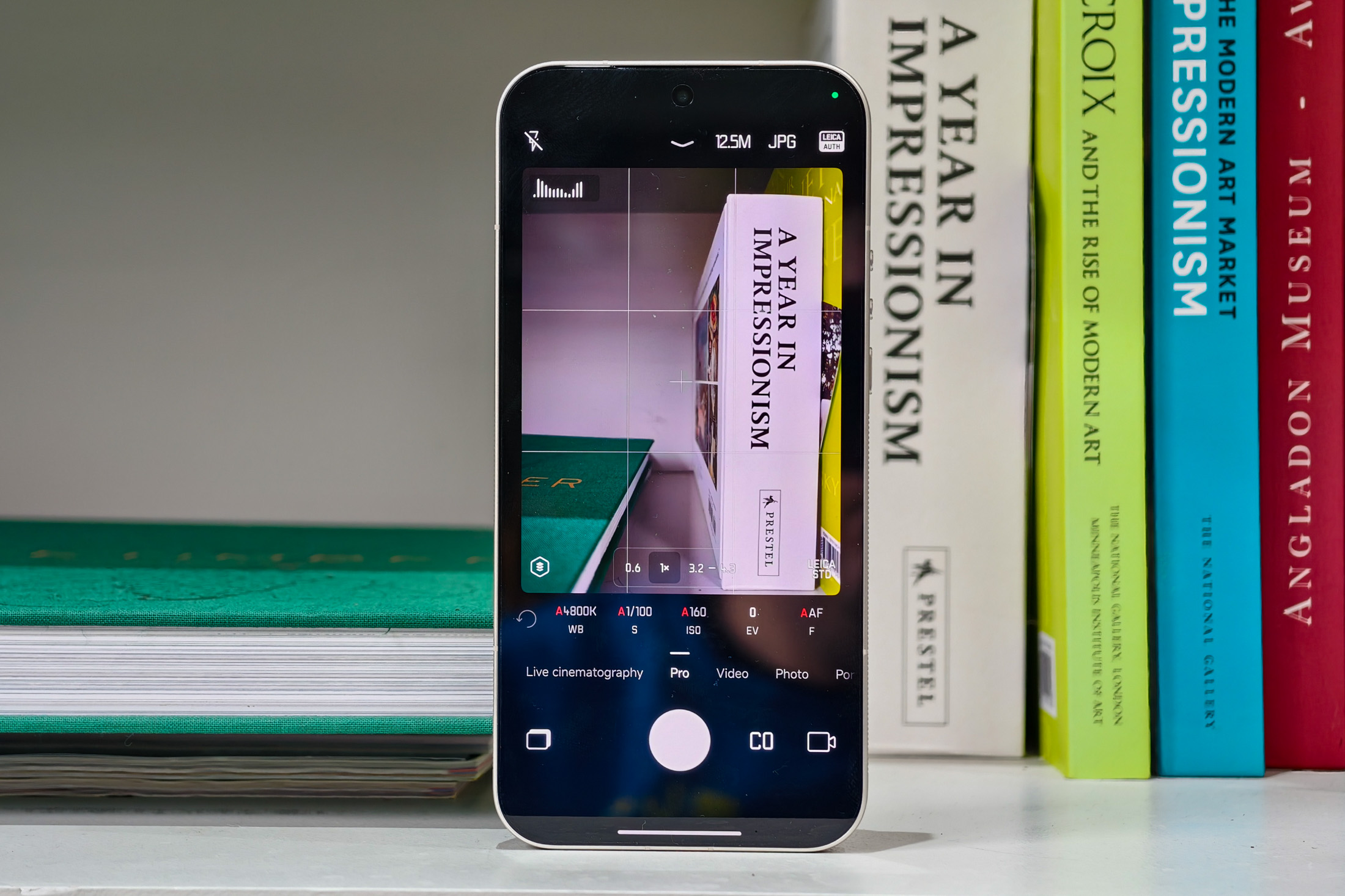 Photo of the Xiaomi Leica Leitzphone on a bookshelf, showing the camera app