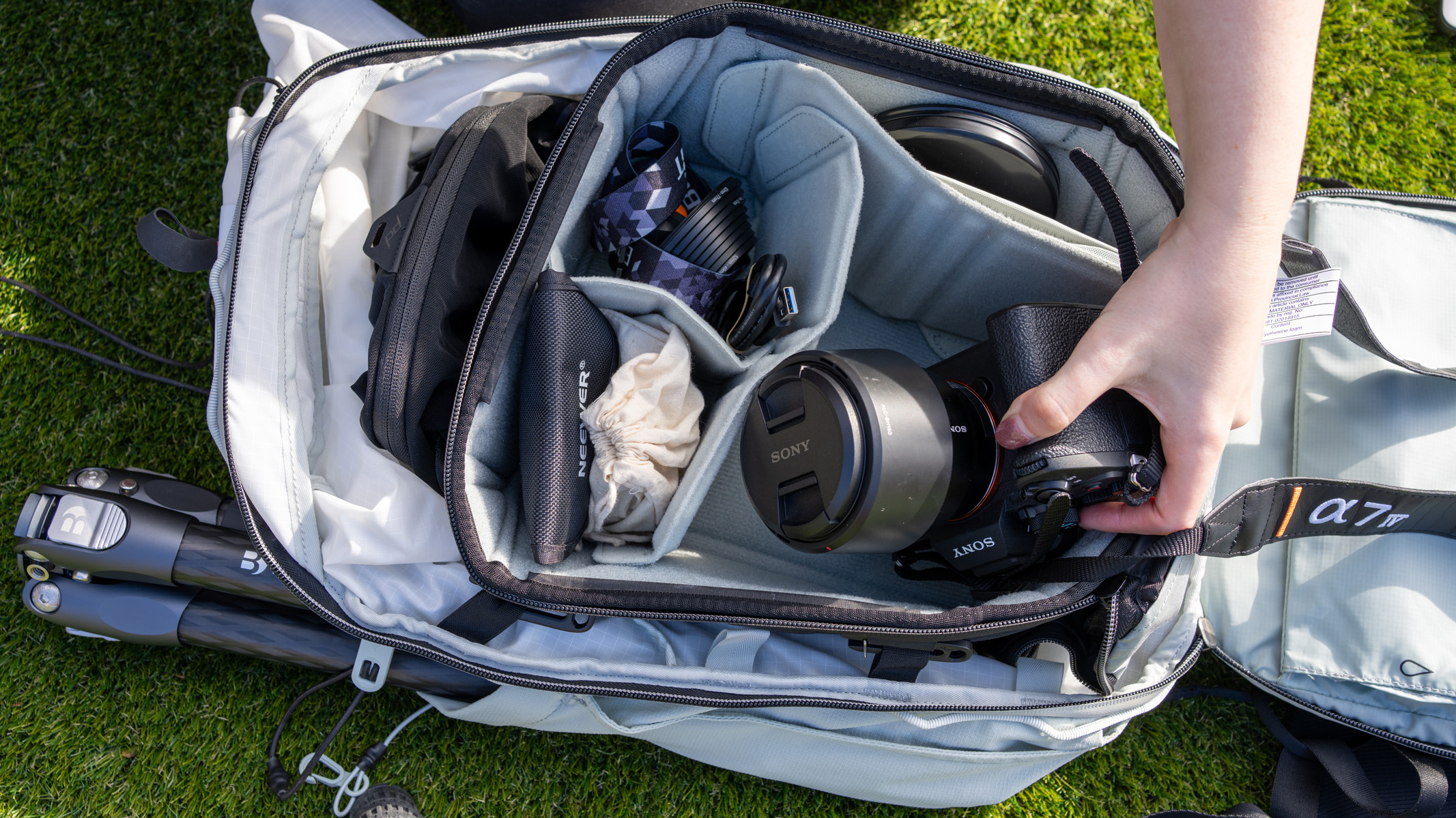 A Peak Design Outdoor Backpack, with a camera and other accessories inside.