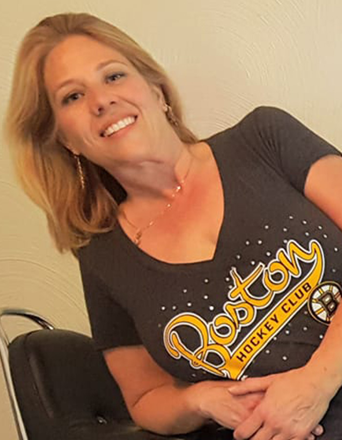 Smiling woman wearing a Boston Hockey Club shirt, related to police discovering disturbing detail about ice rink attacker family. Smiling woman wearing a Boston Hockey Club shirt, related to police discovering disturbing detail about ice rink attacker family.