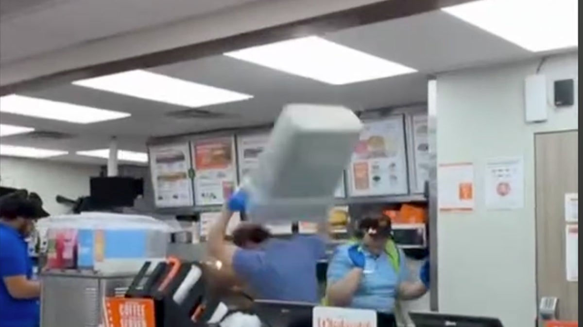 Employee holding trash can during attack.