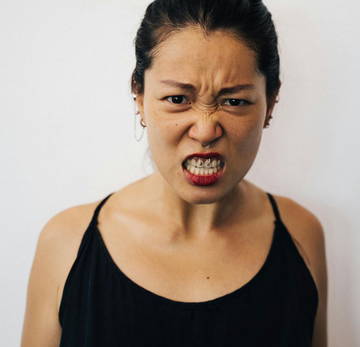 Angry woman expressing frustration, symbolizing a woman going berserk over brother meddling with her parenting.