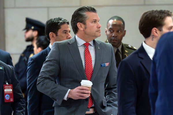 Defense Secretary Pete Hegseth walks to the auditorium to brief members of Congress on military strikes near Venezuela at the Capitol, Tuesday, Dec. 16, 2025, in Washington. (AP Photo/Jose Luis Magana)