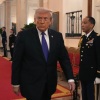 President Trump walks down a red-carpeted hallway in the White House while on the way to award the Medal of Honor to three soldiers.