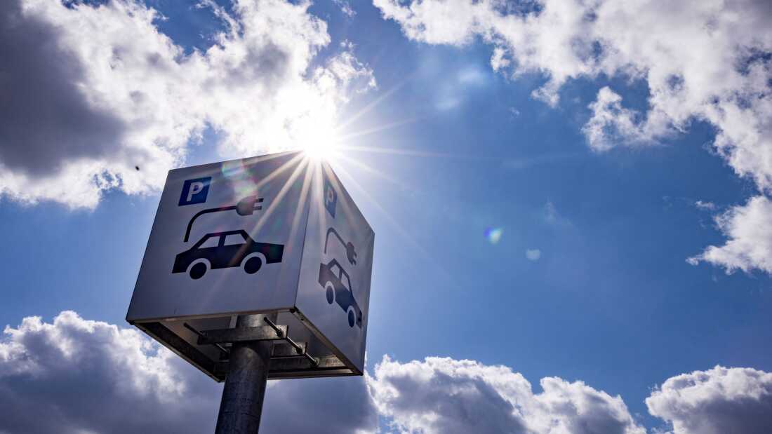 A sign offers parking and charging facilities for electric cars at a retail park in Berlin in 2023. Evidence from the oldest generation of electric vehicles suggests their batteries are lasting longer than was expected in the early days of the EV industry.