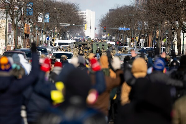 Protesters advance toward federal agents with their hands up near the site of the fatal shooting of 37-year-old Alex Pretti by federal agents in Minneapolis on Saturday, Jan. 24, 2026. (Ellen Schmidt/MinnPost via AP)