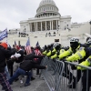 Trump supporters pull on a metal police barrier while police officers hold on to it on Jan. 6, 2021, outside the U.S. Capitol.