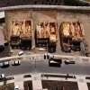 This aerial-view photo shows three homes under construction. The homes are made of wood framing and don't yet have roofs. A complete home is on the left side of the frame.